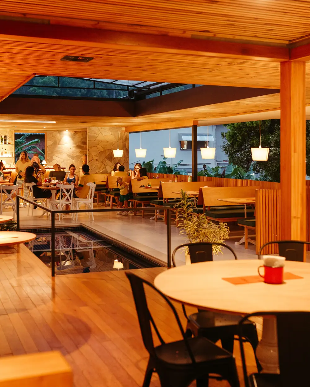 Abendservice in einem Restaurant: besetzte Tische im Hintergrund, ein gedeckter Tisch im Vordergrund noch frei.
